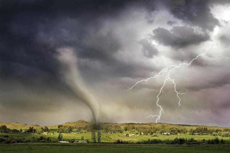 Tornado and lightning hitting small village with gray stormy backdrop